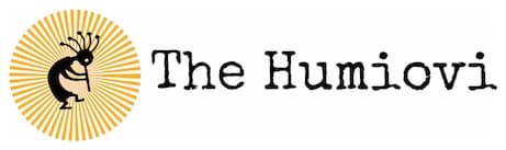 Earlier Humiovi logo: a black Kokopelli inside a yellow sunburst beside typewriter lettering reading The Humiovi