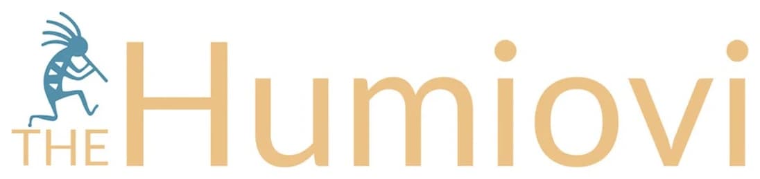 Earlier Humiovi logo: a blue Kokopelli playing the flute beside sand-coloured lettering reading The Humiovi